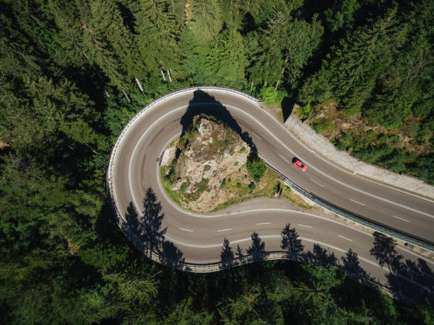 istock aerial view of road going around rock in forest 963427664
