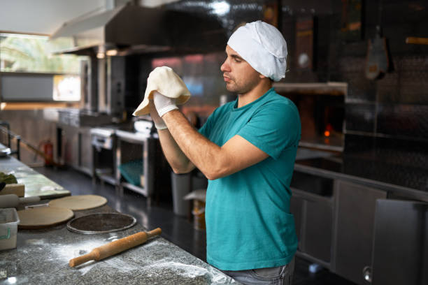 istock chef rolls the dough by hand for pizza 963433442