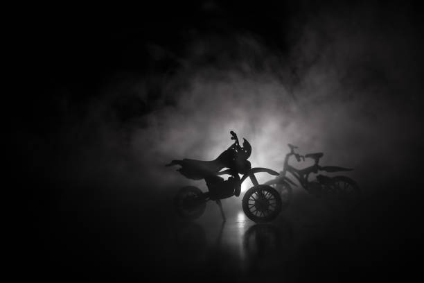 istock High power motorcycle chopper. Fog with backlights on background with man rider at night. Empty space 963437882