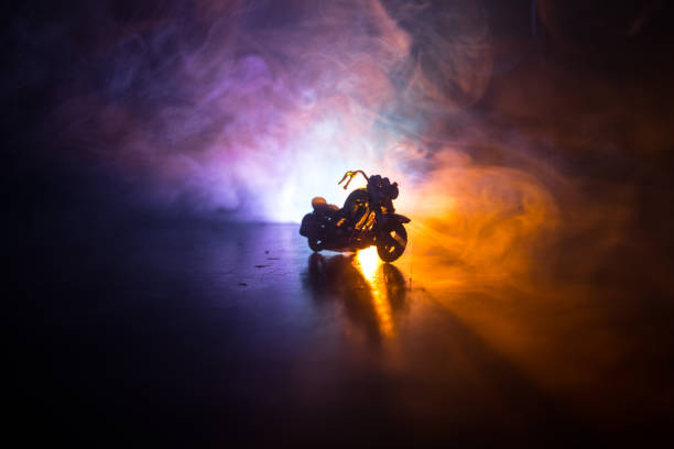 istock High power motorcycle chopper. Fog with backlights on background with man rider at night. Empty space 963437896