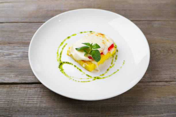Baked polenta with cheese, tomato and pesto sauce