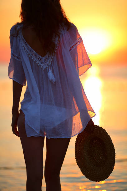 istock Young woman on the beach at sunset 963447462