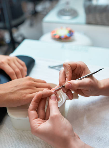 istock procedure cuticle cutting the nails, client's hand and manicure 963448008