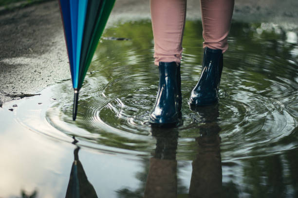 istock Girl wearing rubber boots and has colorful umbrella 963448548