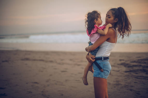istock Mother and cute daughter at the beach 963454142