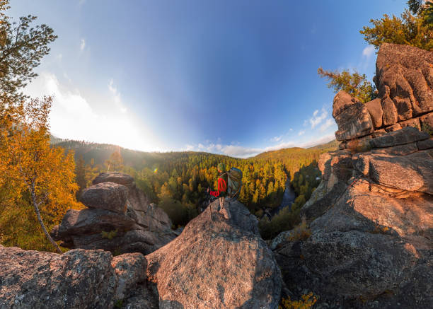 istock Backpacker on top of a rock fall at dawn. Wide angle aerial panorama 963455438