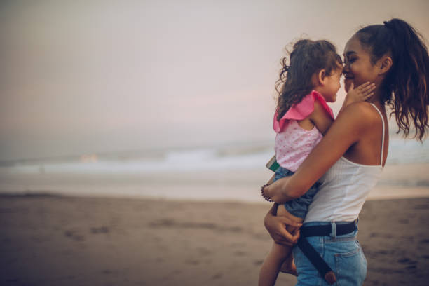 istock Mother and adorable daughter at the beach 963458838
