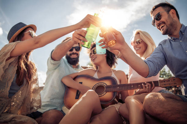 istock Cheerful young people with guitar having fun on the beach 963458980