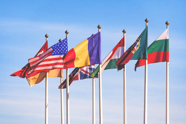 istock Flags of different countries flutters in the wind against a blue sky 963460170