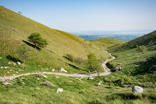 Hiking path towards mountain lodge Hahlić, winding between the green hills of Grobnik Alps, near Rijeka, Croatia