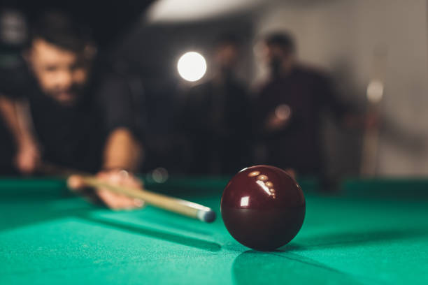 istock young successful handsome man playing in russian pool at bar with friends 963507116
