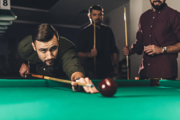 istock young successful handsome man playing in russian pool at bar with friends 963507162