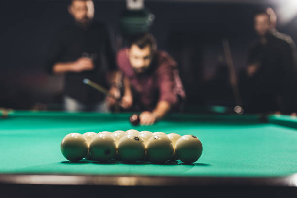 istock handsome man playing in pool at bar with friends 963515574
