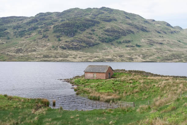 istock Scottish croft ancient lonely single one traditional home on island by loch mountain background green landscape highlands uk 963519034