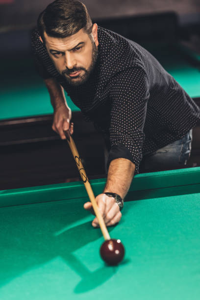 istock front view of handsome man playing in pool at billiard bar 963524266