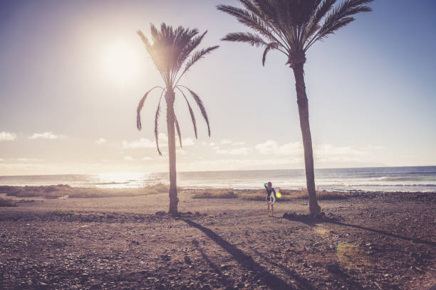 Young female surfer at the beach; Playa Las Americas, Tenerife. Europe / Africa. Nikon D850, All logos removed.