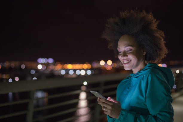 istock Woman using phone after a run at night 963535258