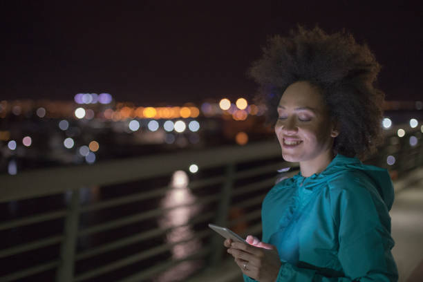 istock Woman exercising outdoors at night and using smart phone 963535268