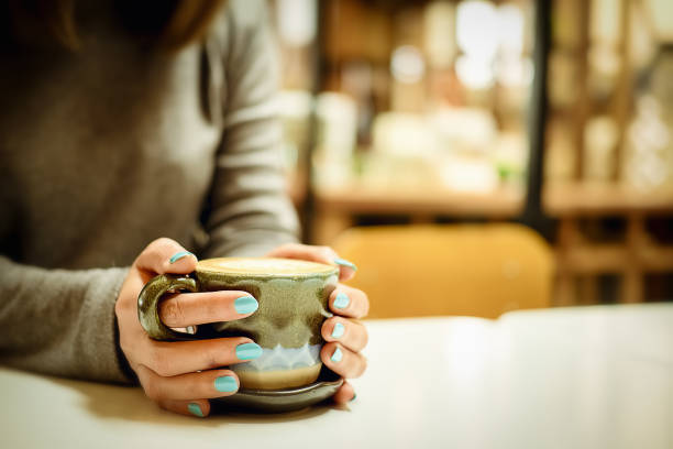 istock Female hands holding cups of coffee with blurred background made 963539696