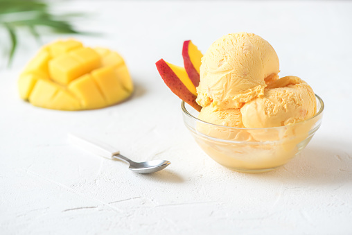 Mango Ice Cream or Sorbet in bowl. Homemade fruit mango ice cream on white background, copy space.