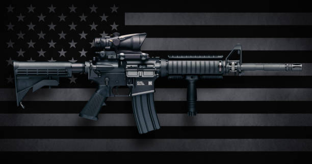 M4A1 Carbine Over USA Flag M4A1 Carbine with ACOG M150 optic commonly carried by US Military personnel, as well as US civilians in semi-auto configuration commonly known as the AR-15.  These were made by Colt Firearms and FN(Fabrique Nationale Herstal, FN America, FN Manufacturing).  Includes standard features such as pistol grip, Knights RAC forearm, collapsible stock, flash suppressor, and bayonet lug. gun control photos stock pictures, royalty-free photos & images