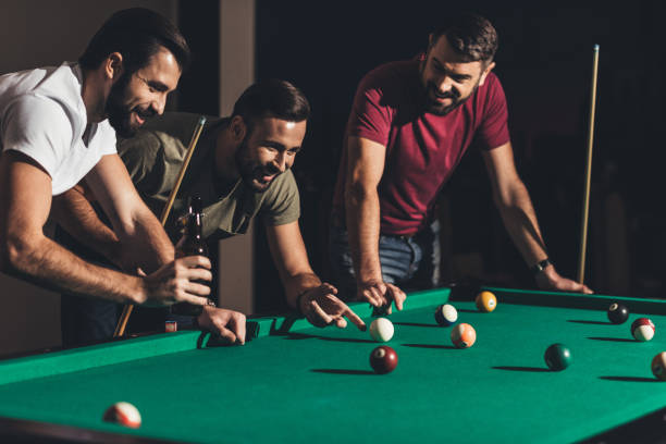 istock group of young handsome men playing in pool at bar 963542630