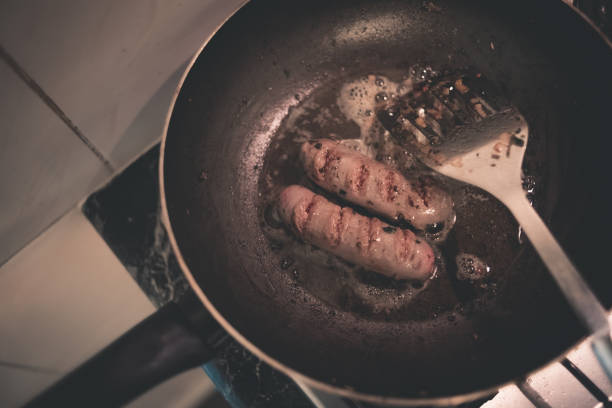 istock hot dogs on pan with oil 963558474