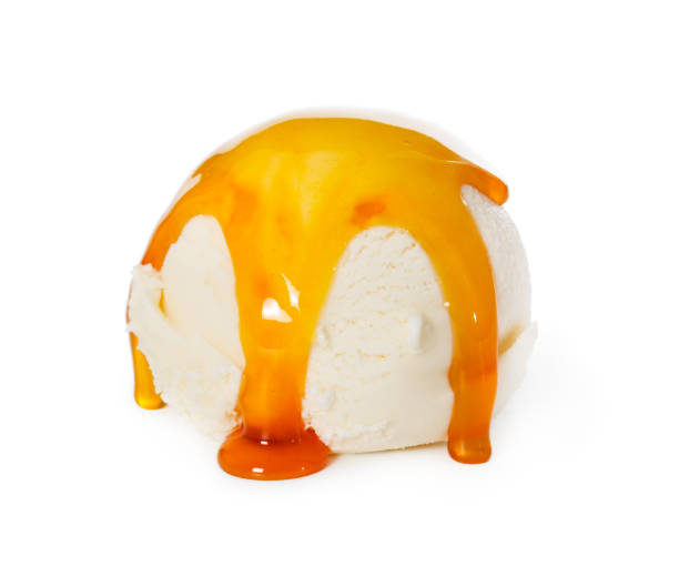 istock Vanilla ice cream ball with caramel syrup isolated on white 963559796