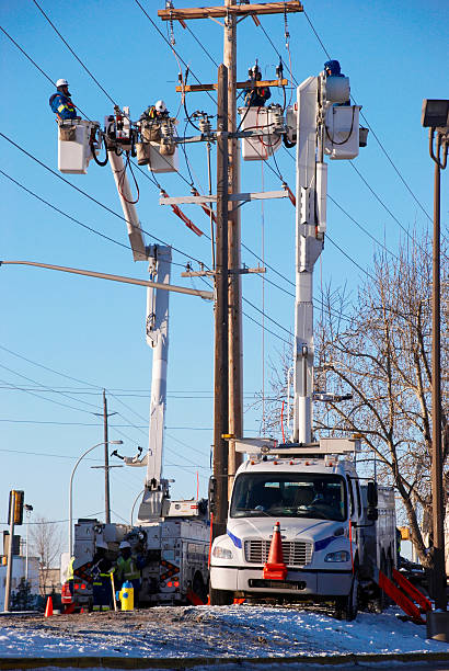 Utility workers fixing power pole stock photo