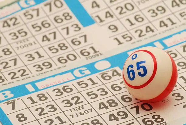 A close-up of a bingo ball on a blue card-face. Low depth of field with focus on ball.