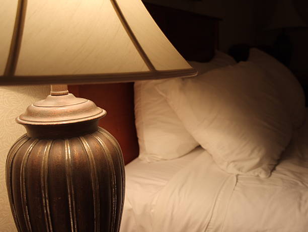 istock bed with propped up pillows and a lamp turned on 96358979