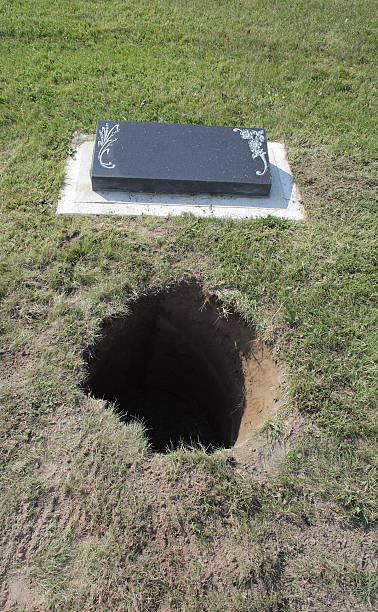istock hole in cemetary for ashes or pet remains with headstone 96358980