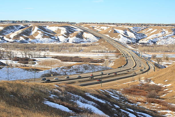 Cars travel on Whoop-up drive through Lethbridge coulee in winter stock photo