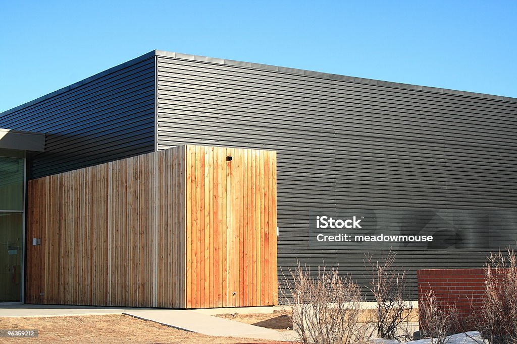 Bâtiment en métal noir avec revêtement contrasté avec avion de planches en bois - Photo de Bleu libre de droits