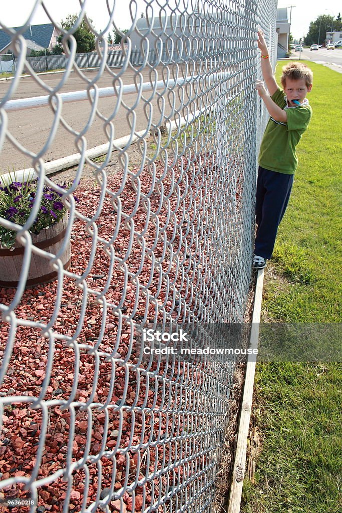 Menino com tamanha capacidade de doces fazer na cadeia link muro - Foto de stock de 8-9 Anos royalty-free