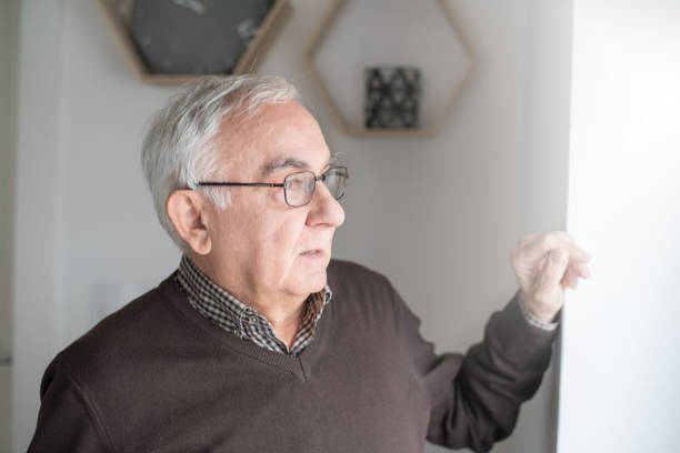 istock Elderly man looking through window in anticipation 963605008