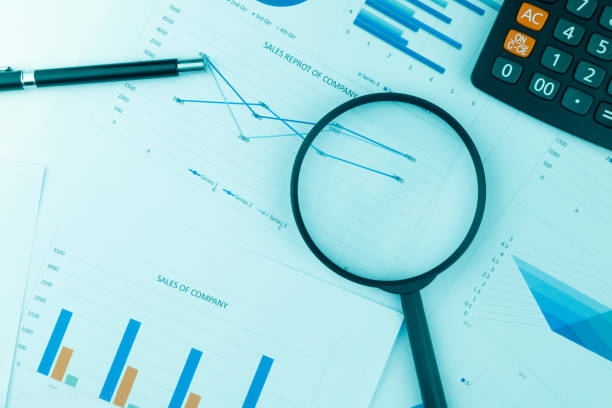istock Business Analysis and Statistics Reports from sales charts last year using a magnifying glass. 963609416