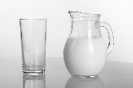 Empty glass transparent jug for milk, cold and hot drinks, isolated on white background.