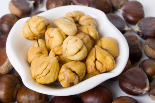 Young woman holding box with different nuts, closeup. Close up, copy space, top view, flat lay. Walnut, pistachios, almonds, hazelnuts and cashews.