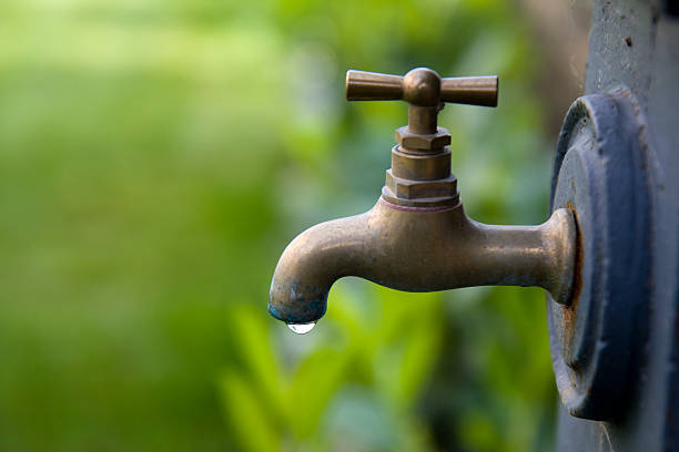 Looking up at a tap against blazing sun. Not a drop of water to be seen