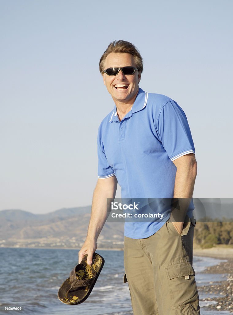Uomo ridendo felice sulla spiaggia a Cipro - Foto stock royalty-free di Maglietta polo