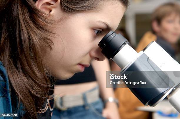 Zbliżenie Dziewczyna Wygląda Przez Mikroskop W Szkole - zdjęcia stockowe i więcej obrazów Badaczka