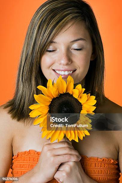 Sorridente Jovem Mulher Olfacto Girassol - Fotografias de stock e mais imagens de Adolescente - Adolescente, Adulto, Beleza