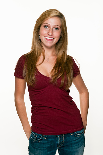 Close up of a standing young blond woman in plain red shirt on white background