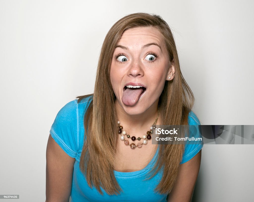 Junge Frau, die Grimassen schneiden - Lizenzfrei Zunge herausstrecken Stock-Foto