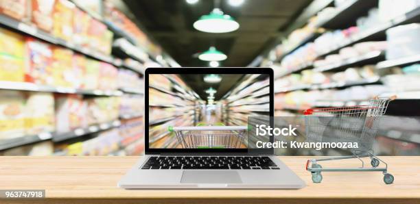 Supermarktgang Unscharf Hintergrund Mit Laptopcomputer Und Wagen Auf Holztisch Onlineshoppingkonzept Stockfoto und mehr Bilder von Internet