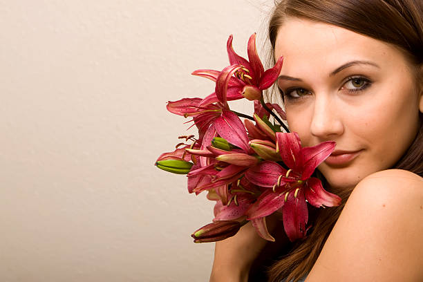 Beautiful girl in the blue dress with flowers tulips in hands on a light background
