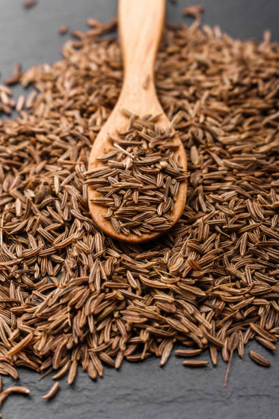 istock Seeds of cumin on a dark stone background 963798786