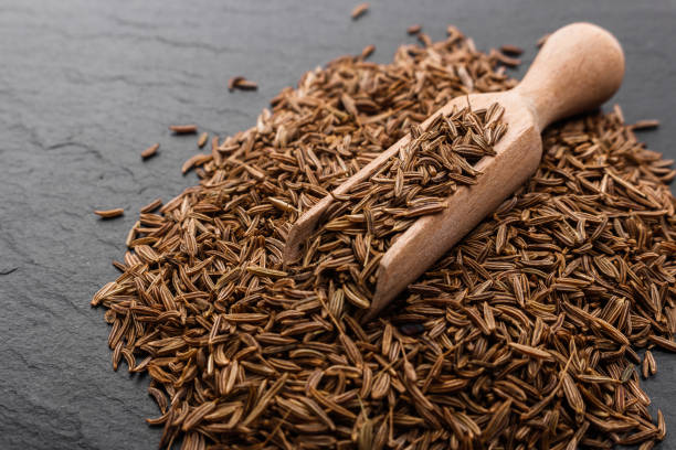 istock Seeds of cumin on a dark stone background 963800204