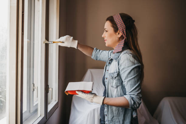 istock Woman painting window frames at home 963801450
